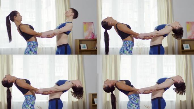 两个女人在练习瑜伽时做站立后弯运动