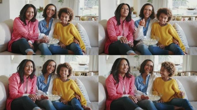 快乐三代女家庭组坐在一起看电视笑着一起吃爆米花