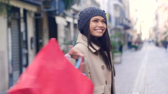 一个年轻漂亮的女孩喜欢在城市商店购物的同时购物。这个女孩拿着许多彩色的手提包。