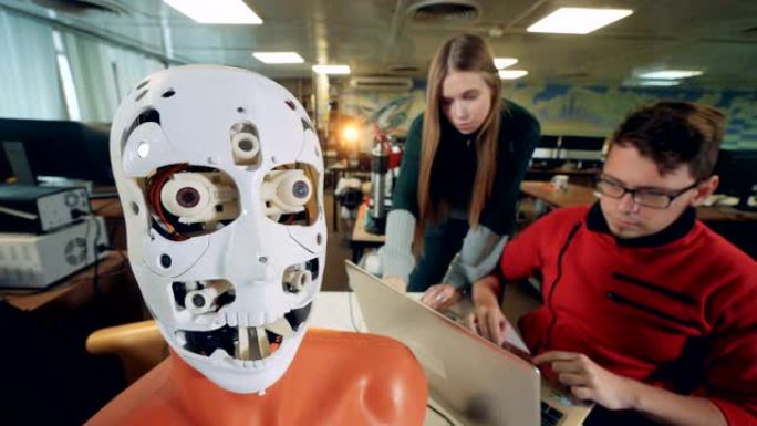工程师检查机器人移动的舌头。与未来派人形机器人合作的工程师。