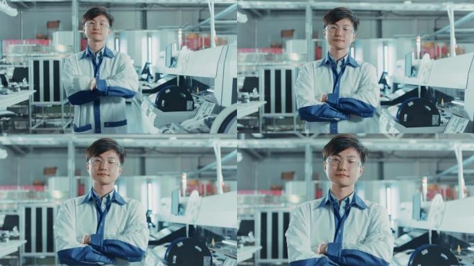 高科技工厂: 双臂交叉的亚洲工人肖像。在使用表面安装技术和拾取和放置机械的背景电子印刷电路板装配线中