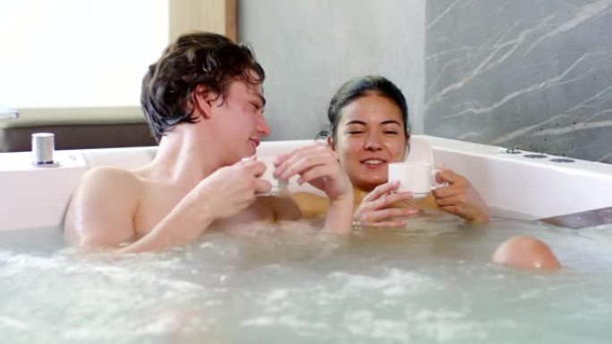 夫妇在热水浴缸里喝凉茶