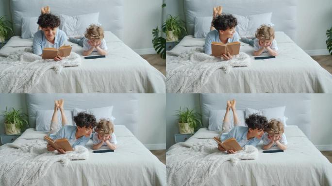 慈爱的妈妈看书，然后在卧室里用平板电脑和儿子一起看动画片