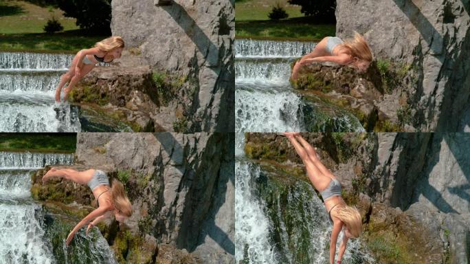 慢动作: 健美的女孩首先跳到瀑布边缘的池塘里。
