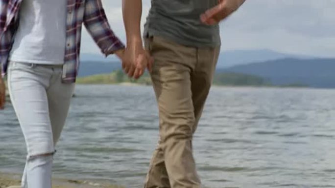 夫妇牵着手在湖边散步