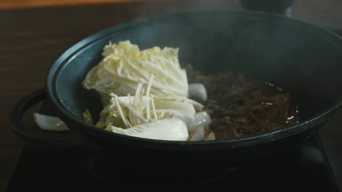 4k Dci日本料理的镜头，寿喜烧牛肉，葱在平底锅上搅拌和油炸