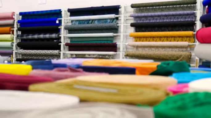 在一家纺织商店里，有各种颜色和各种材料的织物，例如织物，蕾丝，缎子，亚麻。