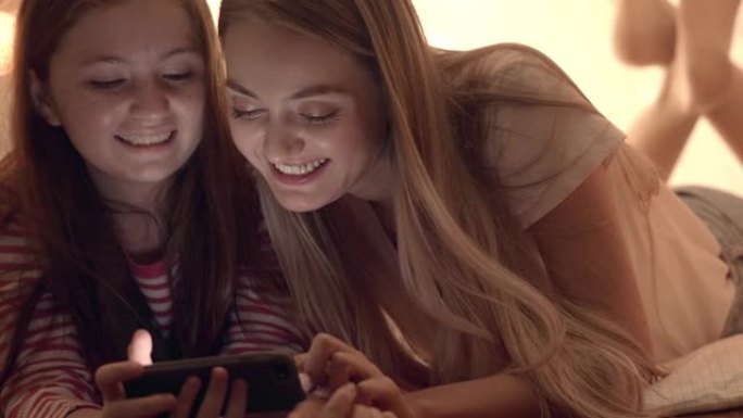 年轻的母亲和她的女儿在使用平板电脑时玩得很开心