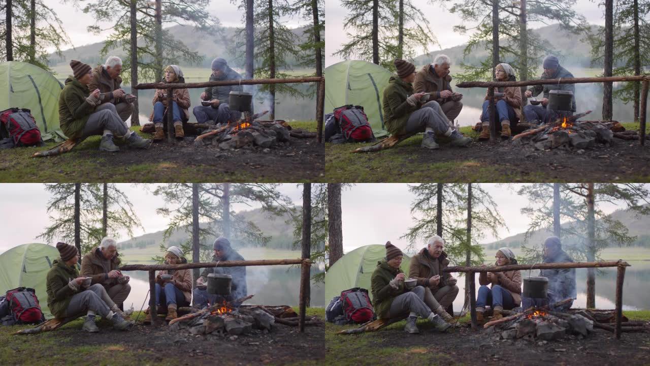 资深朋友在营地的壁炉旁吃晚餐
