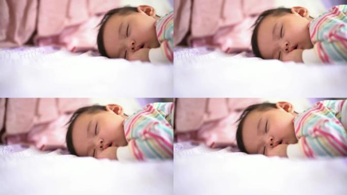 一个4个月的亚洲女婴在家床上睡觉