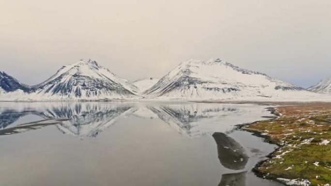 冬季在海边的冰岛山脉倒影的鸟瞰图