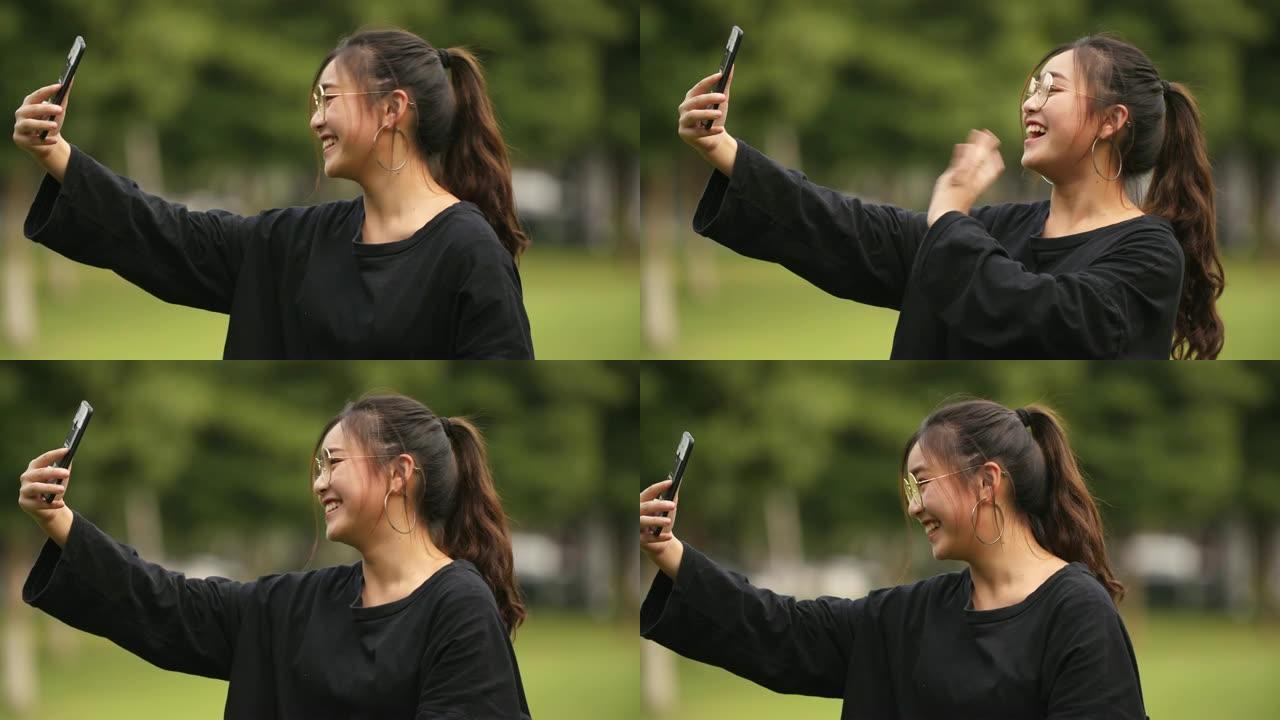 亚洲大学女生在校园里用手机视频聊天