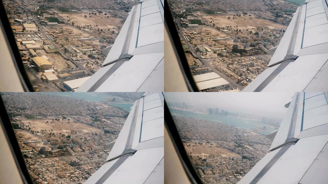 起飞后不久，从靠窗座位上看到飞机机翼的美丽景色，在美丽的阳光明媚的沙漠城市上空飞行。