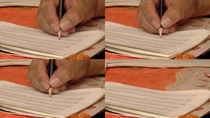 用铅笔在乐谱上写音符。特写。