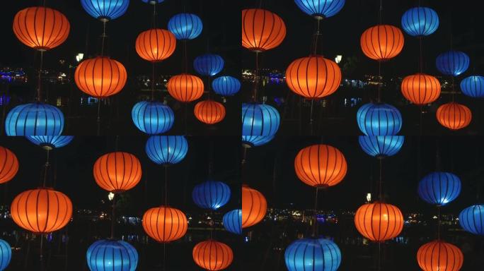 特写: 橙色和蓝色的东方灯笼在节日的夜晚闪耀着明亮的光芒。
