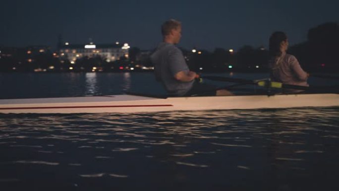 运动员夜间在河里划船