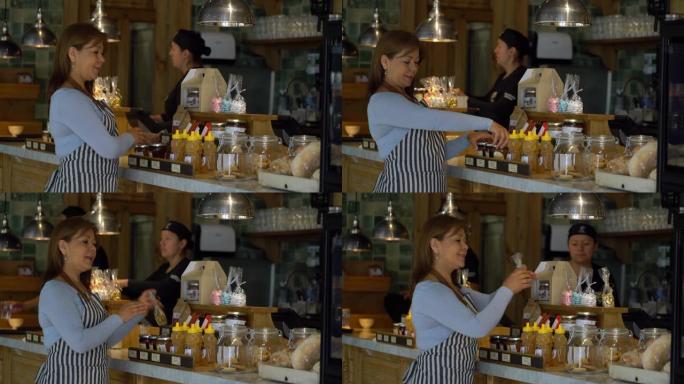 一家面包店开朗的女企业主，用美味的产品安排柜台展示