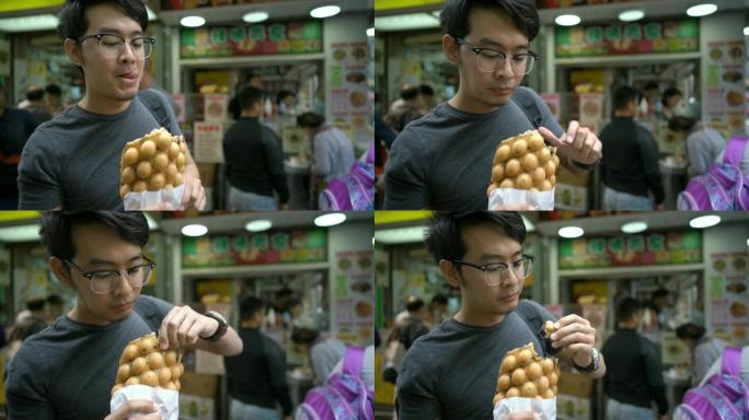 游客吃香港特色小吃鸡蛋华夫饼/泡泡华夫饼