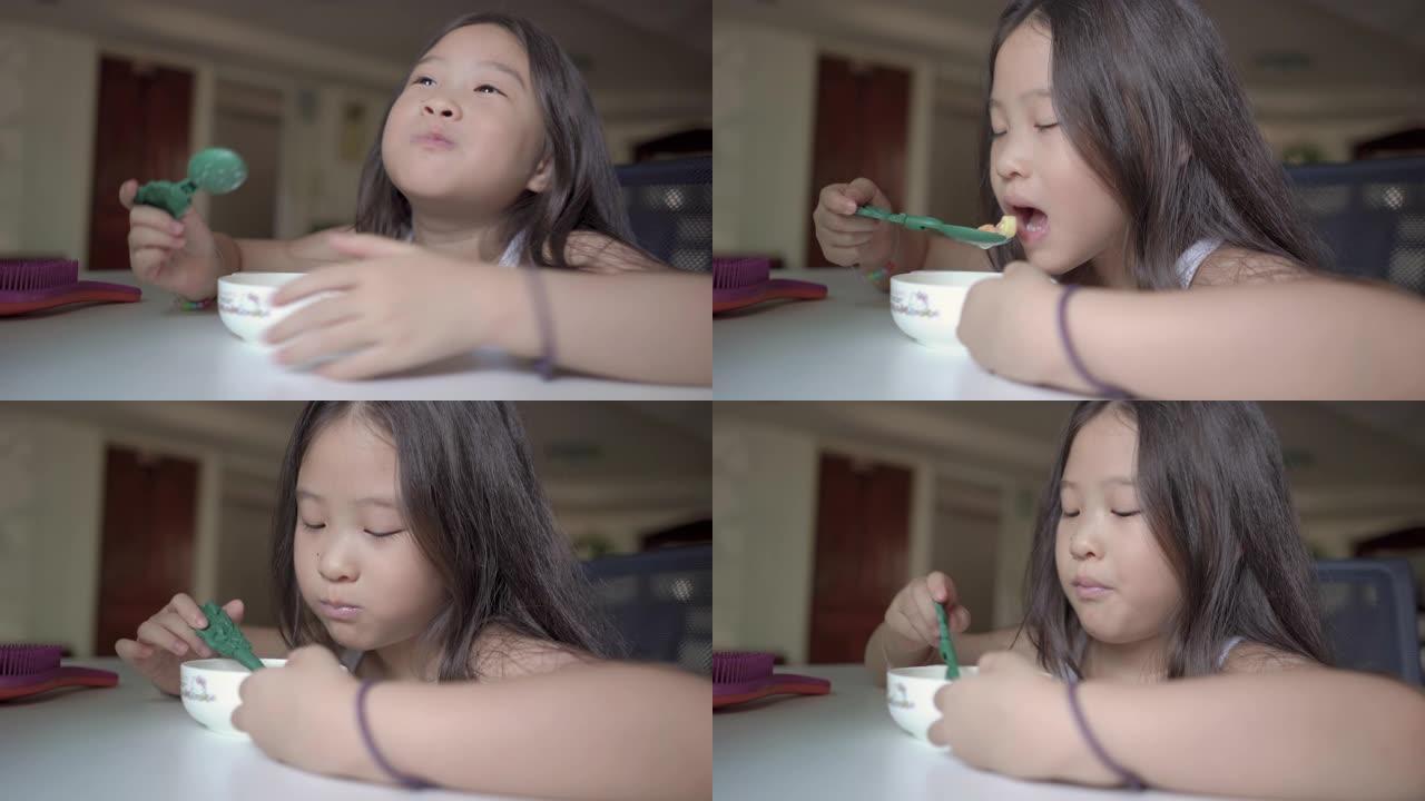 特写可爱的亚洲小女孩早上吃麦片