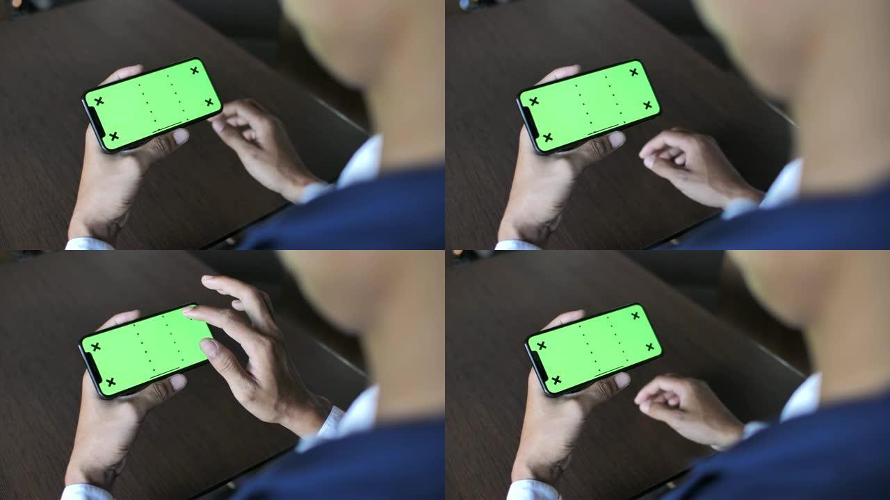 男子使用智能手机与绿屏握在手中，水平