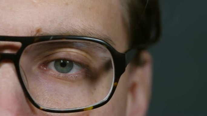戴眼镜的人的眼睛与电脑一起工作