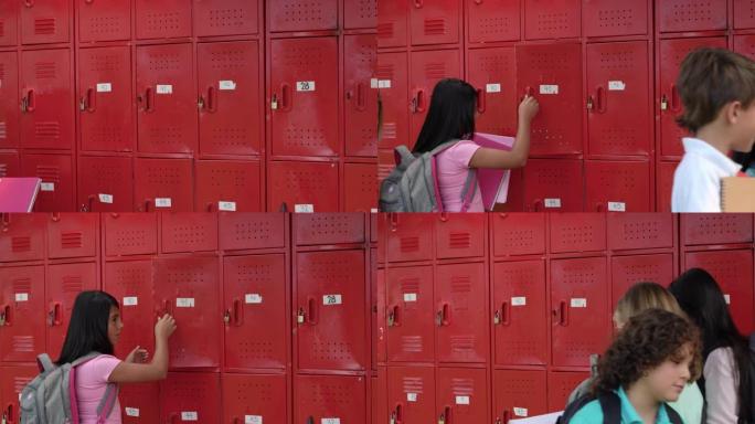 中学的女学生在学生走时将笔记本放在储物柜中