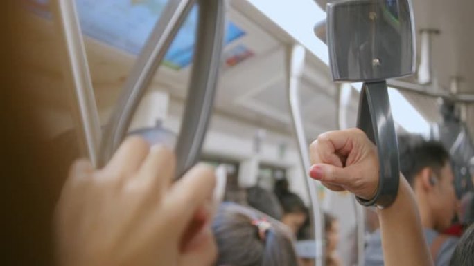 地铁列车中手握扶手或抓握带的特写镜头，慢动作