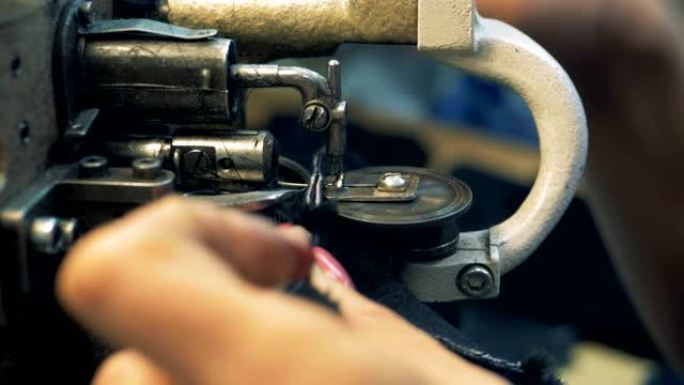 女裁缝在一台特殊的机器上缝制皮肤，特写镜头。