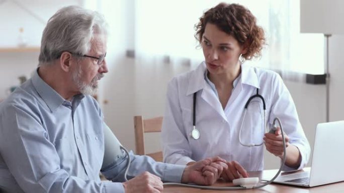 女医生测量老年男性患者的血压