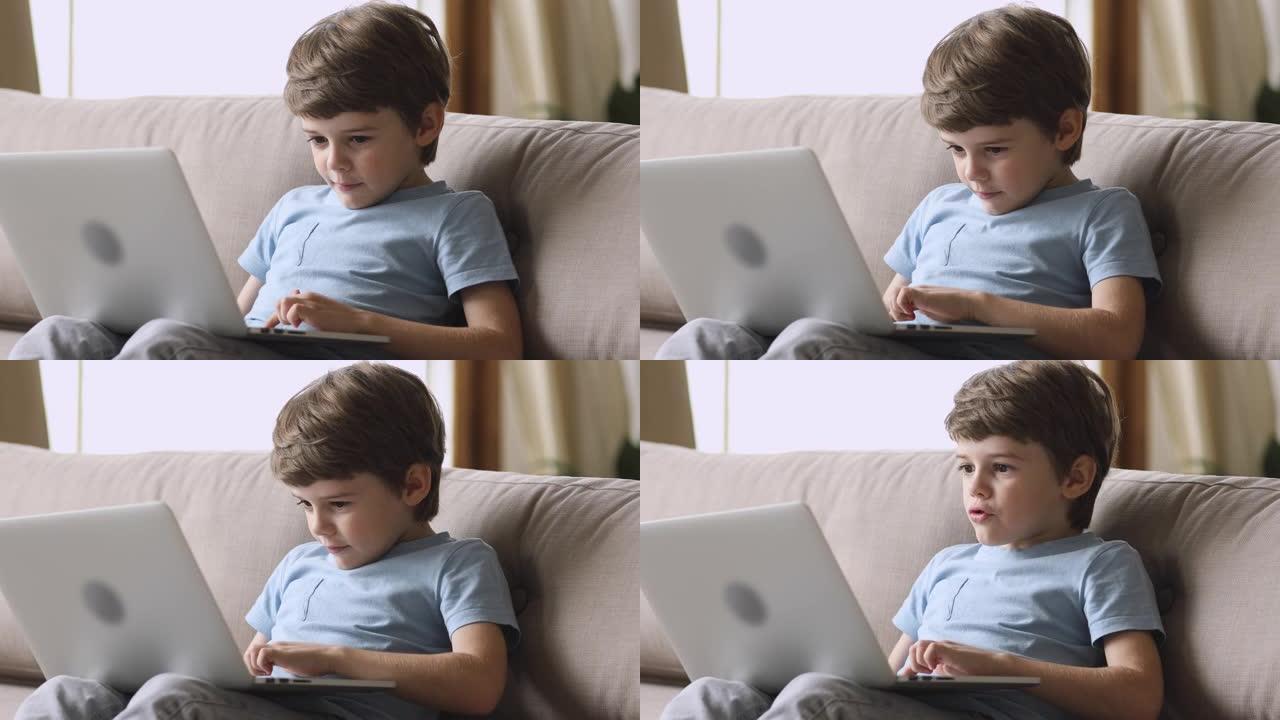 沉迷于技术快乐的小孩在笔记本电脑上玩游戏。