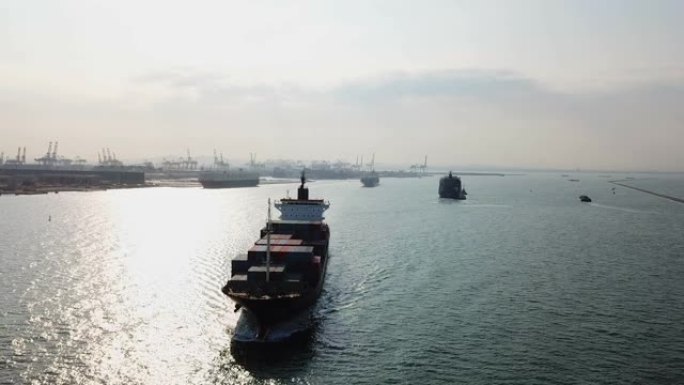 货船载运货柜驶往港口出口