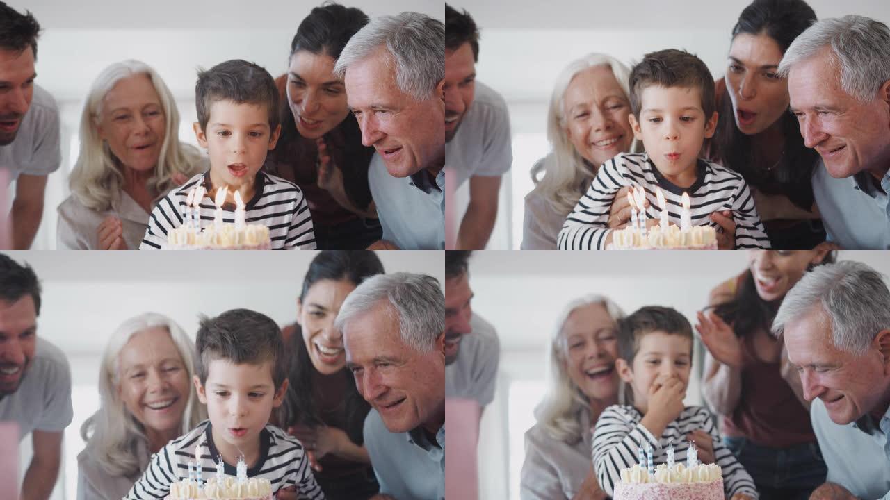 多代家庭在家里与孙子一起庆祝生日，吹灭蜡烛
