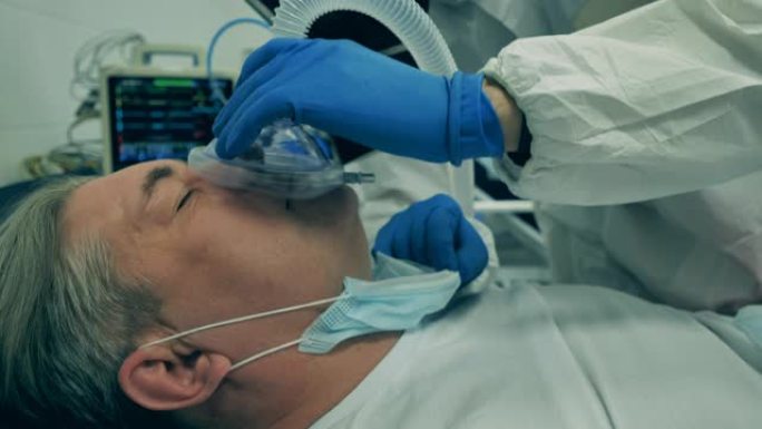 冠状病毒，新型冠状病毒肺炎医院重症监护室的病人。一位医生在治疗冠状病毒患者时塞住呼吸装置。