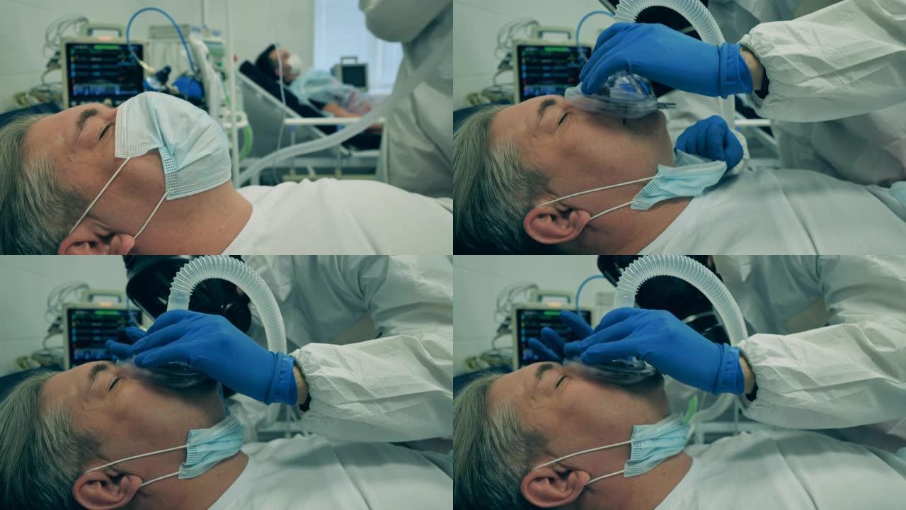 冠状病毒，新型冠状病毒肺炎医院重症监护室的病人。一位医生在治疗冠状病毒患者时塞住呼吸装置。