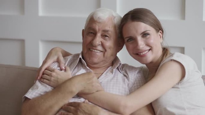深情的年轻女子拥抱快乐的老退休父亲。