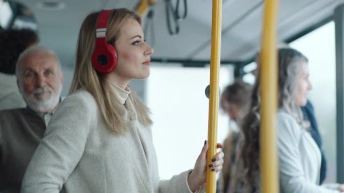 公共汽车上戴着耳机的女人