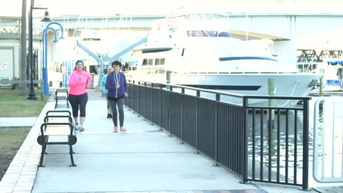 三名西班牙裔妇女一起锻炼，跑步