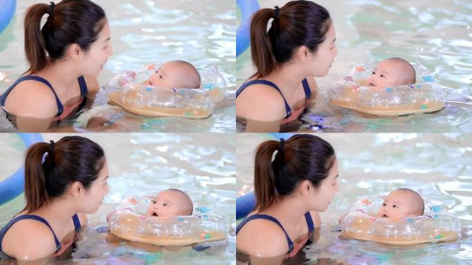 可爱的婴儿和他的母亲一起在游泳池里