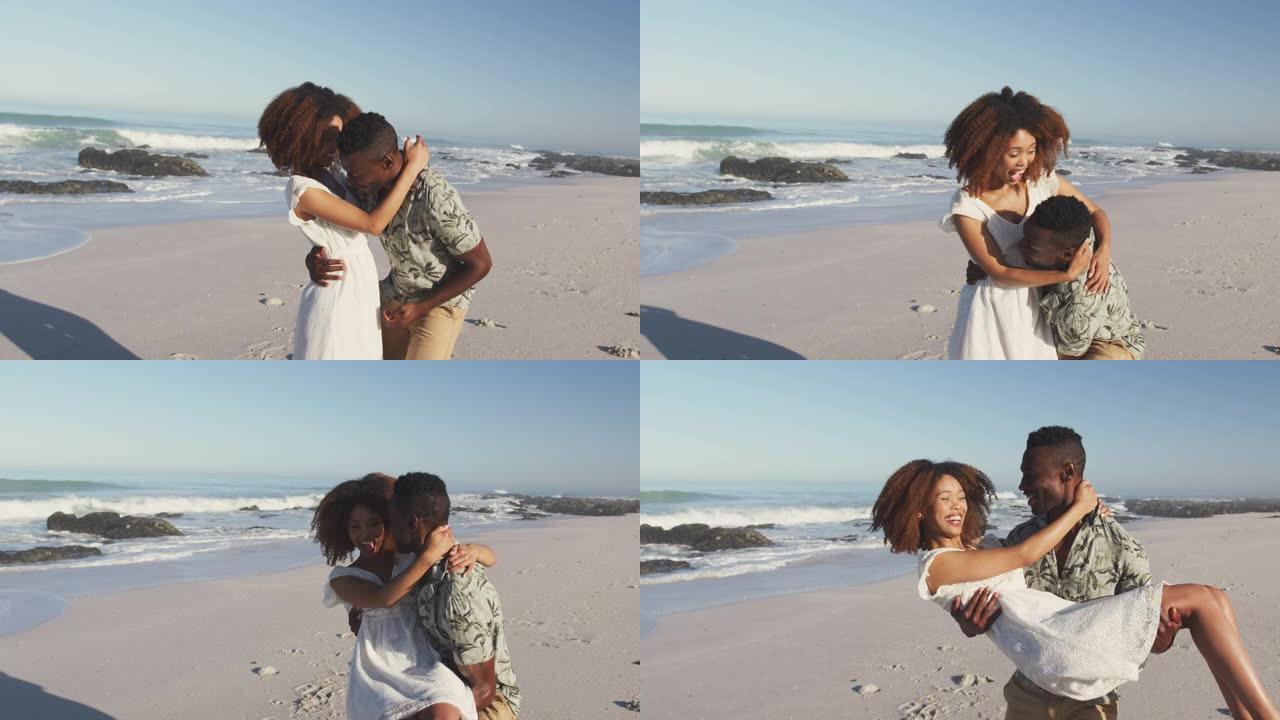 非裔美国男子拥抱并抱着妻子海边