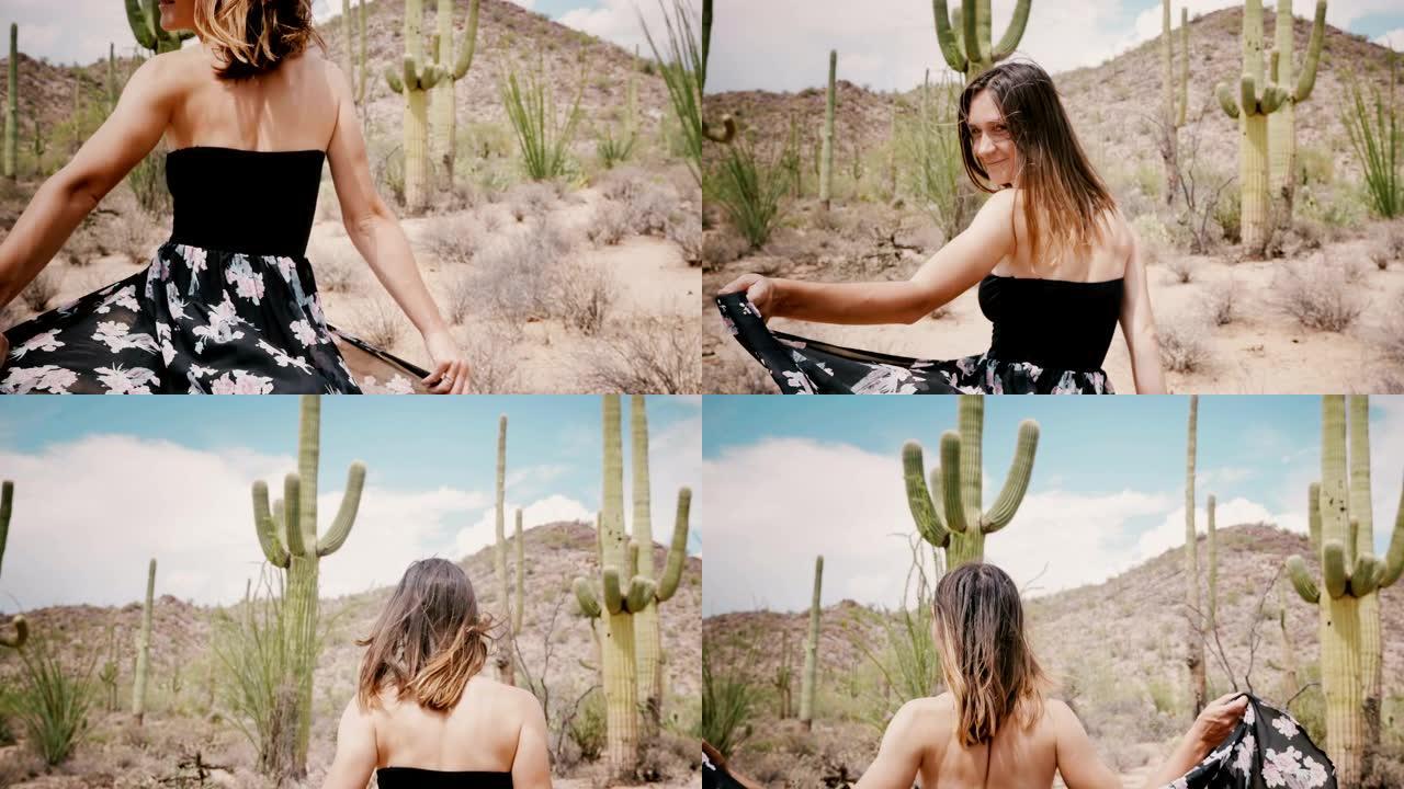 慢动作相机跟随年轻的微笑快乐的旅游女人，在史诗般的阳光明媚的仙人掌沙漠美国行走。
