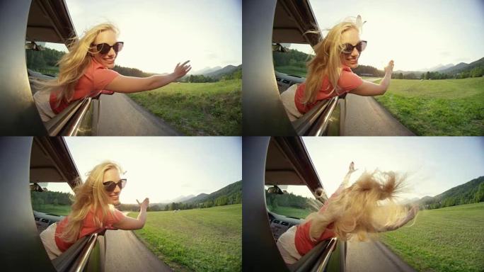慢动作: 金发女孩在开车时伸出手臂穿过窗户。