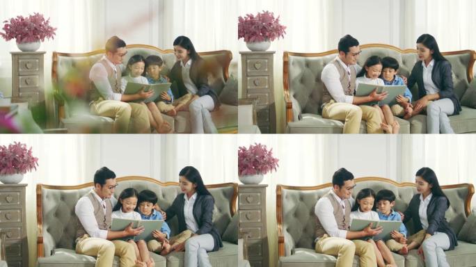 亚洲母亲和父亲在家与儿子和女儿一起读书