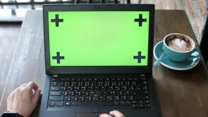 女人看着绿色屏幕的笔记本电脑，视线