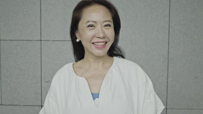 一位迷人的亚洲高级女性微笑的慢动作视频