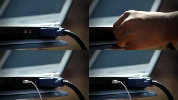 男性手将耳机电缆连接到笔记本电脑。特写。