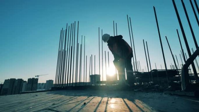 建筑工人正在用手提钻打碎混凝土。建筑工地的建筑工人。