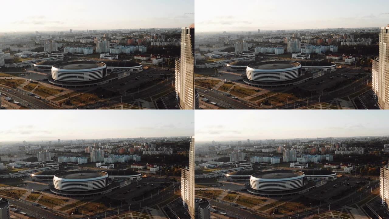 在晴朗的秋日，雄伟的日出期间，无人机在明斯克竞技场城市体育场周围飞行，白俄罗斯的城市全景。