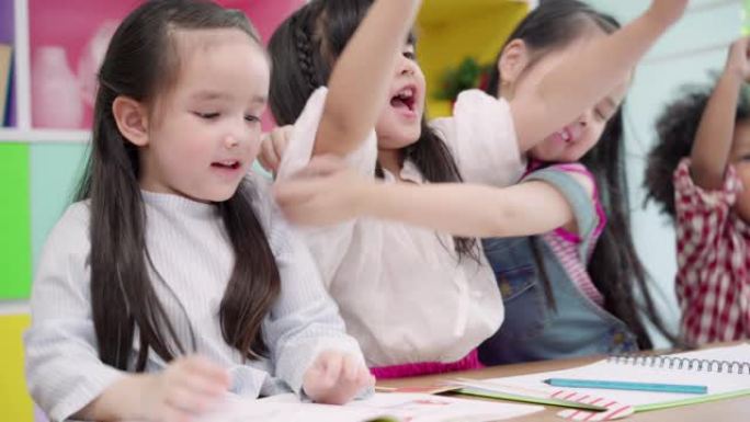 一群孩子在教室里画画，多民族的年轻男孩和女孩在小学快乐有趣的学习和在纸上画画。孩子们在学校画画的概念