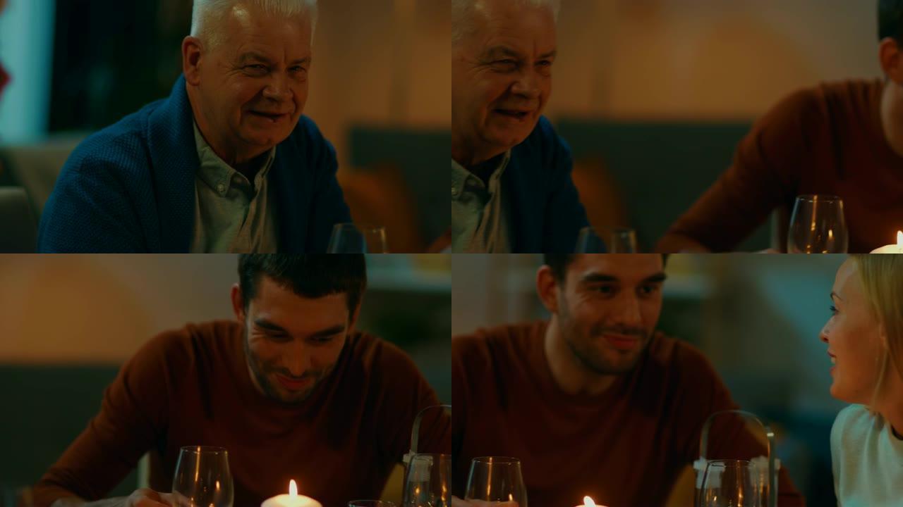特写肖像: 老人和年轻人在餐桌上玩得开心。人们说话、开玩笑、吃喝。
