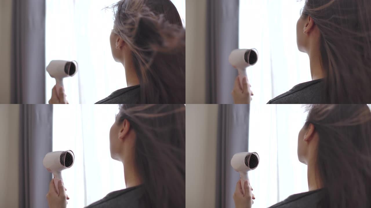 亚洲妇女用吹风机吹干头发